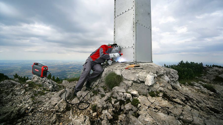 stick welding a steel structure on top of a mountain using a battery powered welder