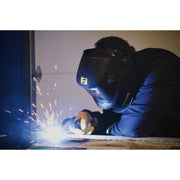 man MIG welding while wearing black esab savage welding helmet