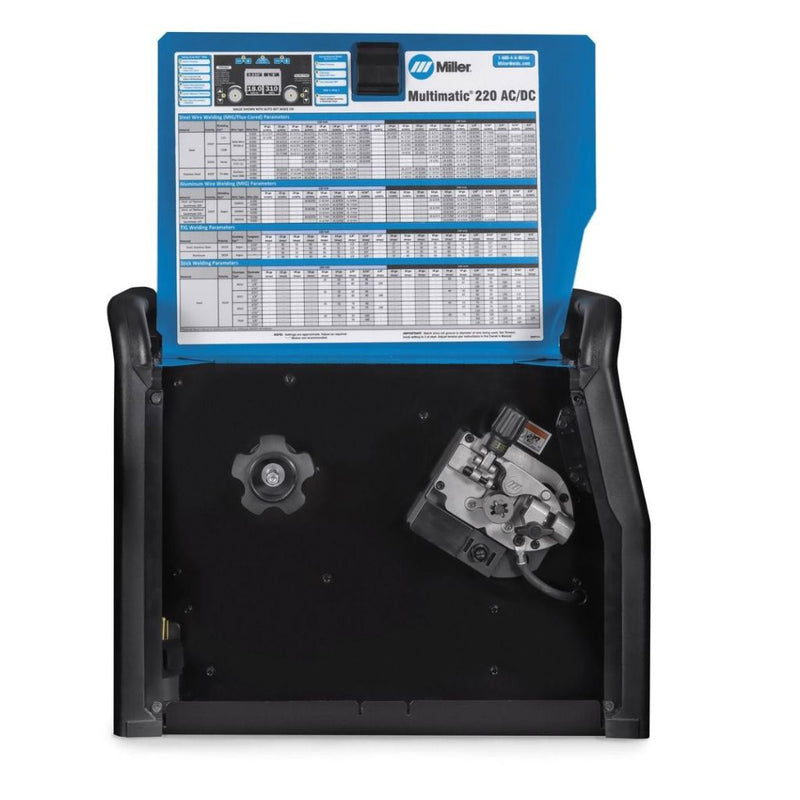 inside of miller multimatic multiprocess welder showing drive rolls and welding parameter chart