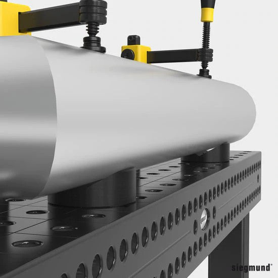 close up of steel pipe being supported by two 80mm prisms on siegmund system 16 welding table
