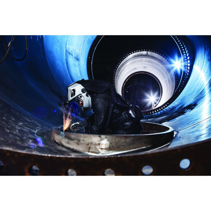 Showing a welder working inside a cylinder, wearing the Miller T94i-R PAPR helmet and utilizing the grind shield.