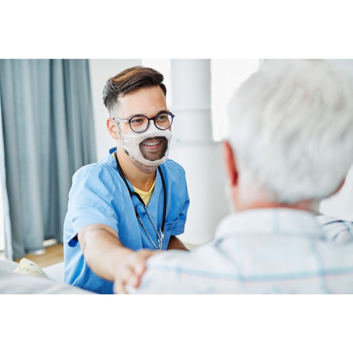 a male doctor smiling at an elderly medical patient while wearing a clear n95 respirator mask